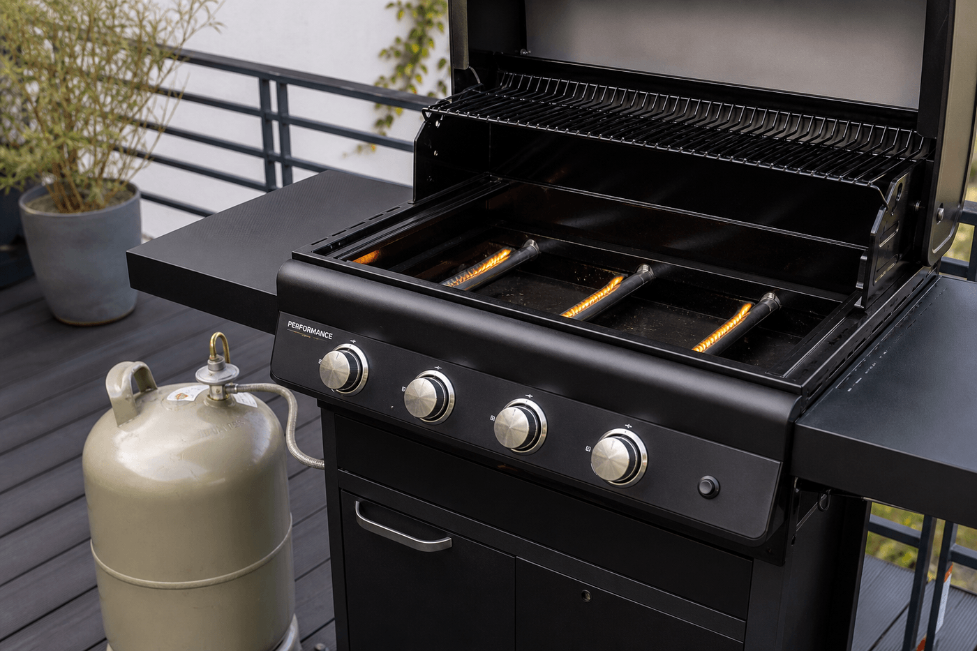 Barbecue à gaz avec une flamme faible et jaunâtre au niveau des brûleurs, bouteille de gaz visible à côté sur une terrasse